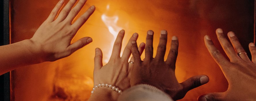 Hands keeping warm by the fireplace