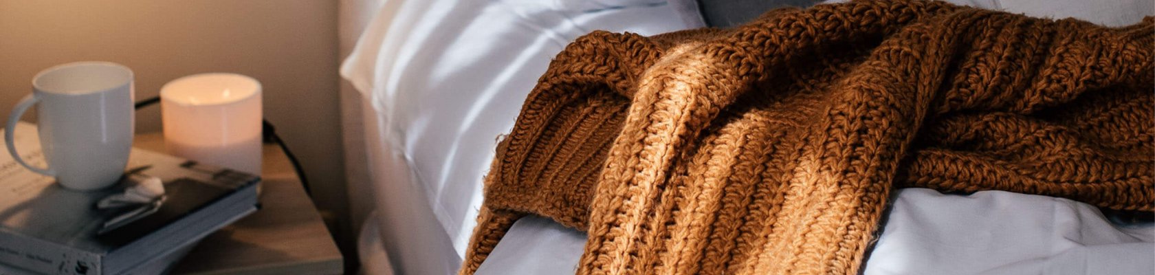 Cosy blanket and coffee cup on the bed