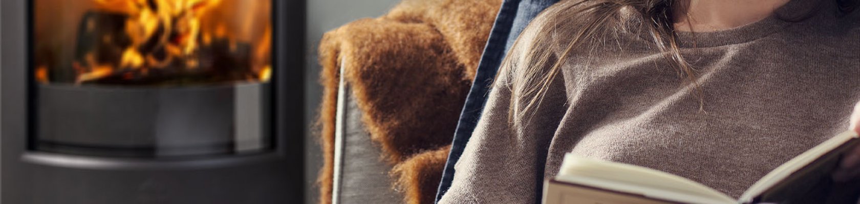 Woman sitting in front of wood burning stove Jøtul F 373 Advance