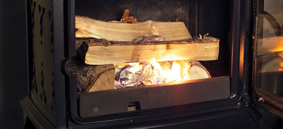 Lighting fire in wood stove. Photo.