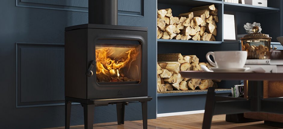 Jøtul F 205 black wood burning stove in a dark blue living room with firewood