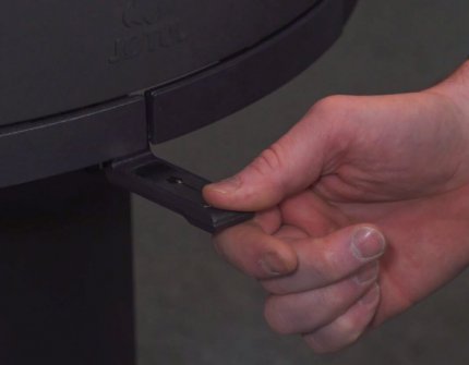 The hand regulates the air supply in the fireplace