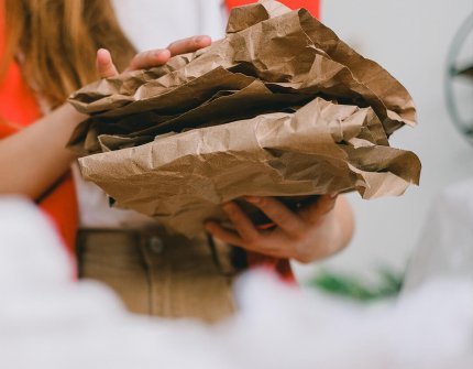 Woman carrying cardboard in her hands 
