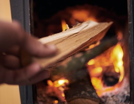 The hand that puts the firewood in the fireplace