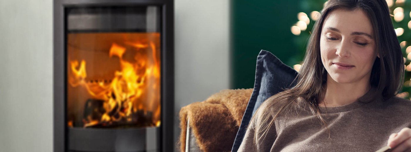 Woman in front of her fireplace at Christmas