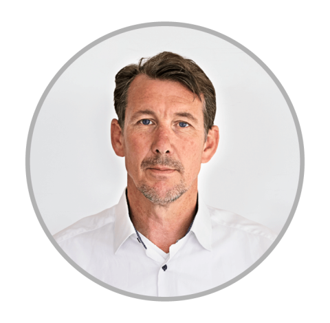 Portrait of man with brown hair and blue eyes, wearing a white shirt