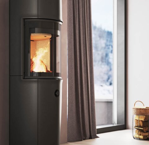 Modern room with large black Jøtul F 176 wood stove, powder purple walls and snowy mountain view