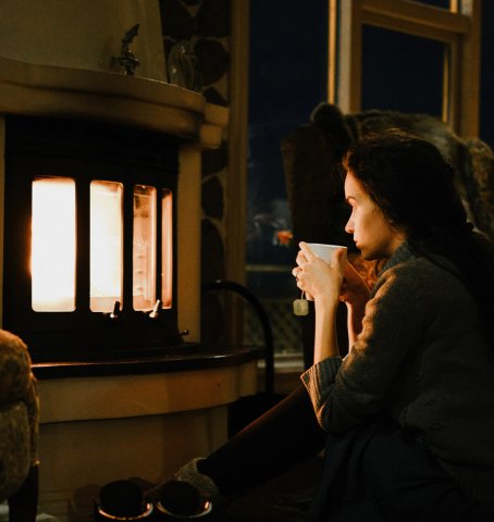Lady sitting in front of the fireplace in the evening